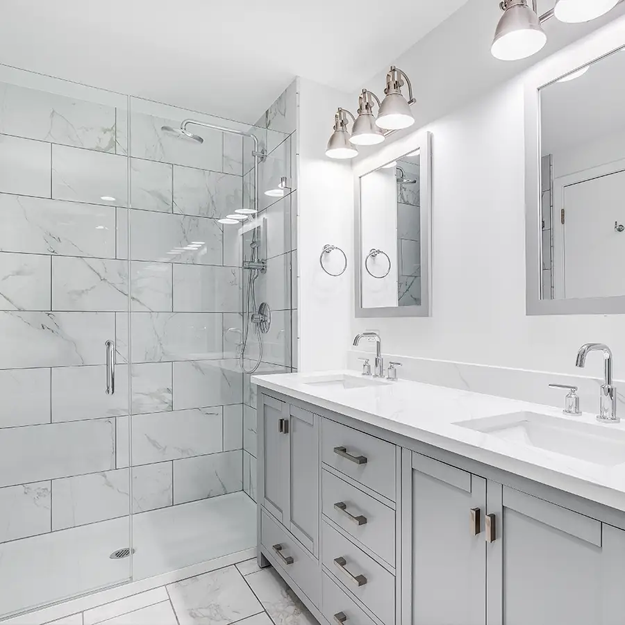Modern bathroom with glass shower and double vanity.
