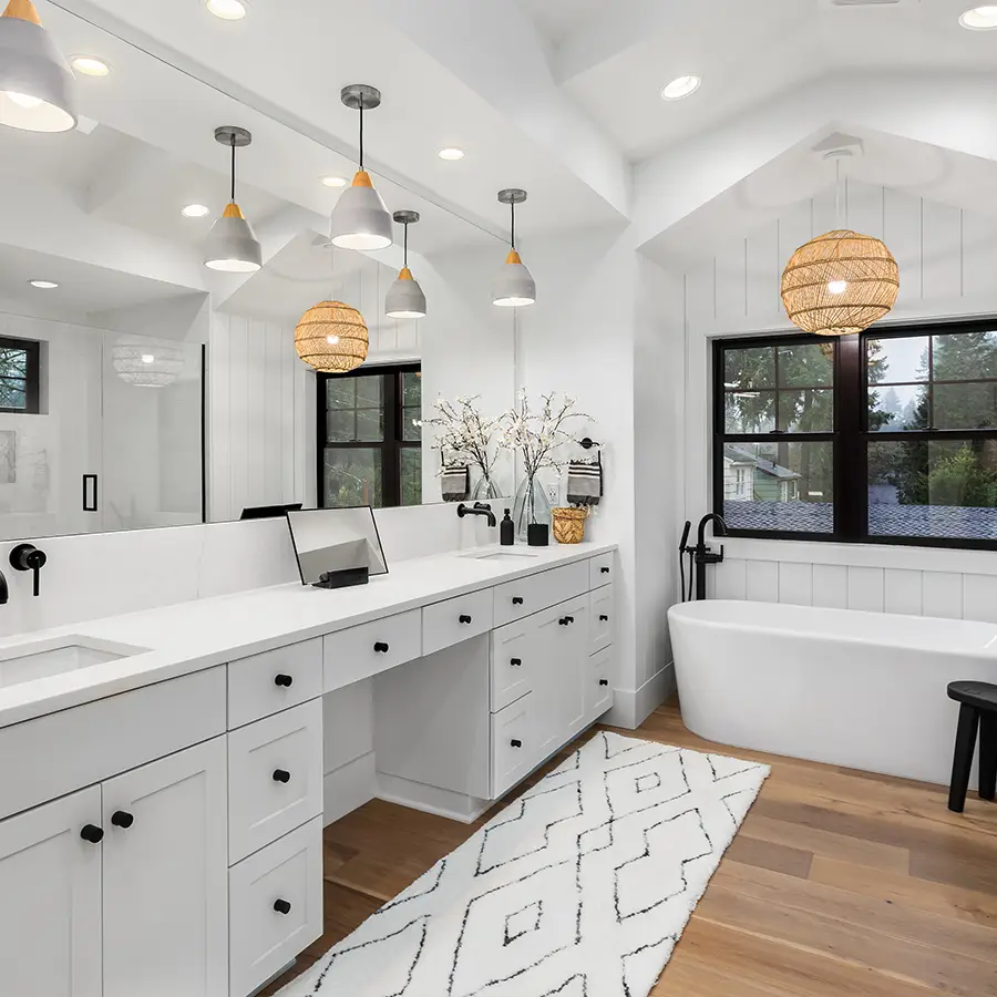 Modern white bathroom with tub and double vanity.