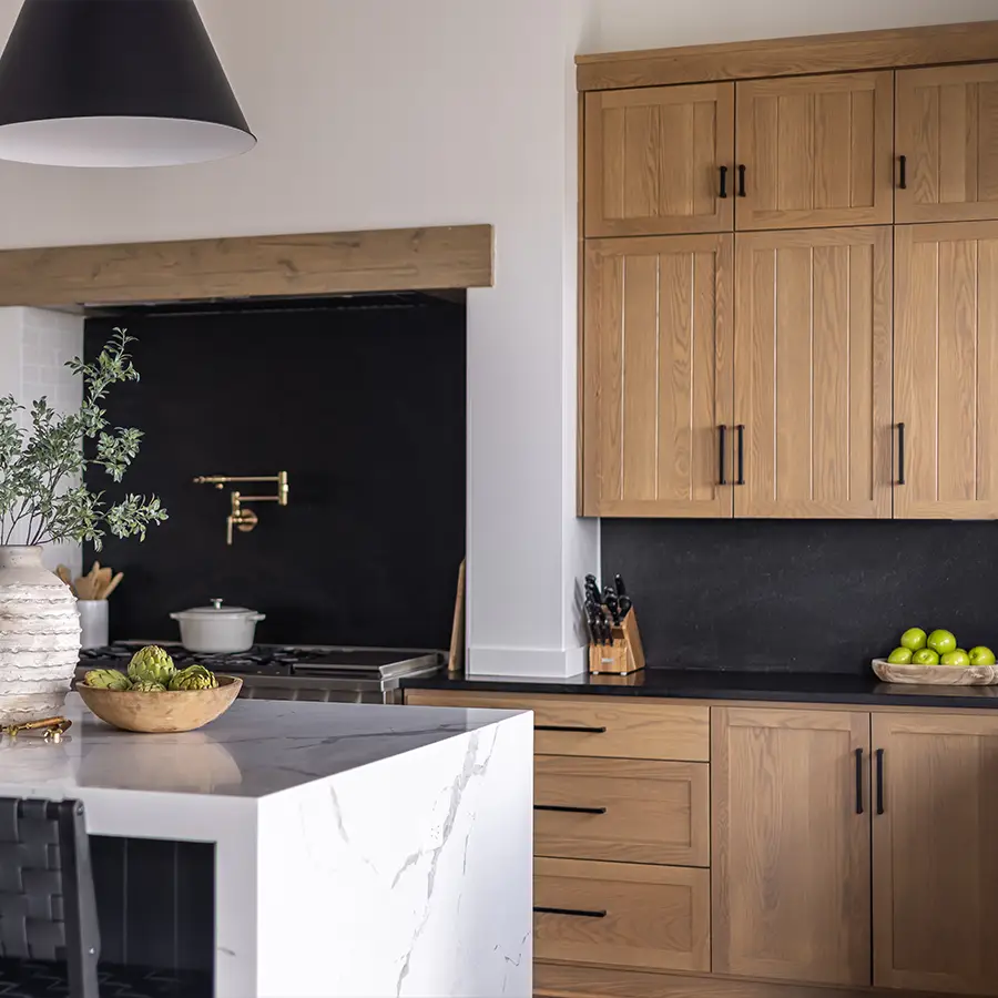 Modern kitchen with wooden cabinets and marble island.