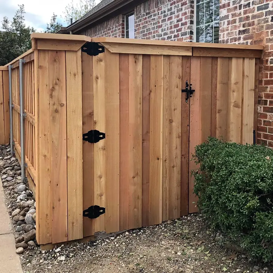 Wooden fence with gate and brick wall background