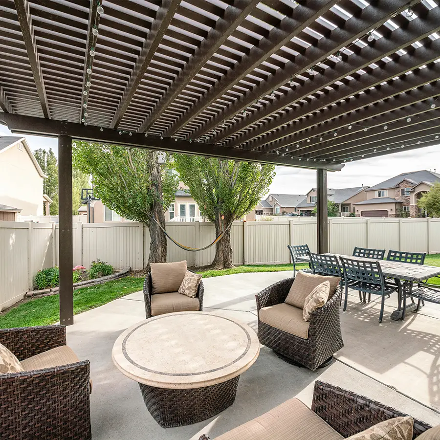Outdoor patio with pergola and wicker furniture.