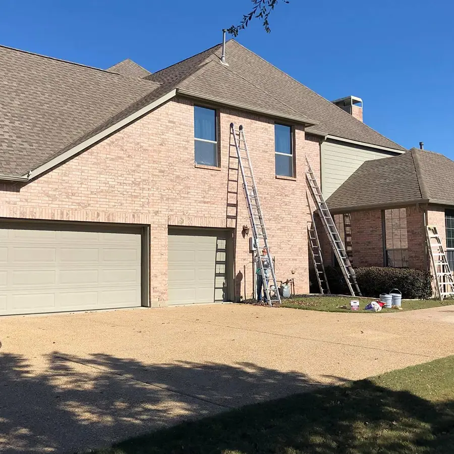 House exterior with ladders and roofing supplies.