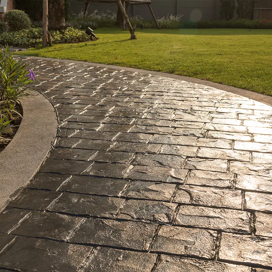 Stone pathway beside green lawn in sunlight